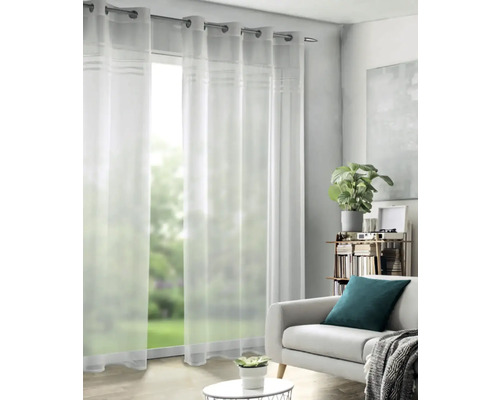 Průhledné závěsy s očky před oknem v obývacím pokoji