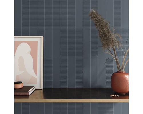 Nástěnná dekorace s podlouhlými dlaždicemi a dekorativními prvky na polici