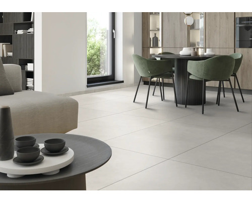 Světlý obývací pokoj s dlažbou, jídelním stolem a posezením.