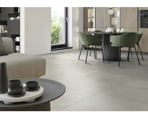 Světlá obývací místnost s dlažbou, jídelním stolem a pohovkou