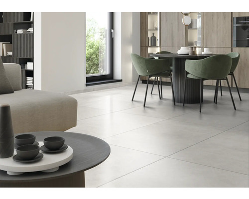 Světlý obývací pokoj s dlažbou, jídelním stolem a posezením.