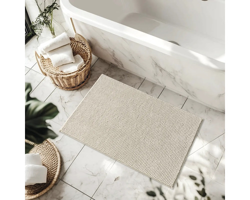 Koupelna se scénou s vanou, koupelnovým kobercem a koši s ručníky