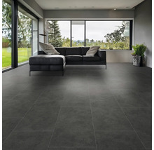 Moderní obývací pokoj s velkoformátovými šedými podlahovými dlaždicemi a černou koženou pohovkou