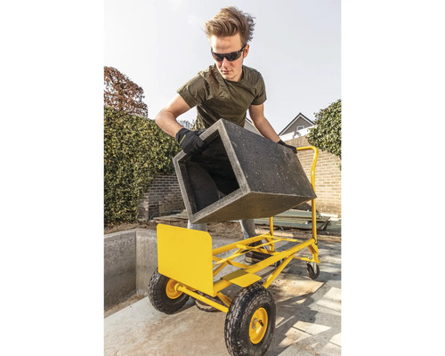 Muž přepravuje květináč s přepravním vozíkem na zahradě