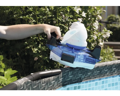 Ruka umisťuje čistič bazénu na okraj bazénu.