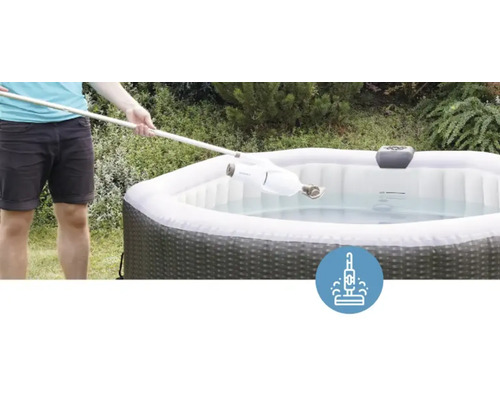 Osoba čistí nafukovací vířivku pomocí vysavače