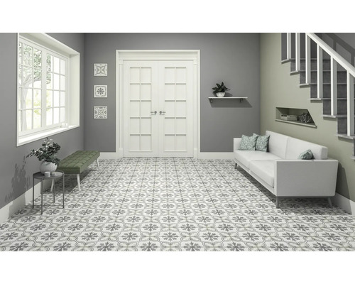 Světlá chodba se vzorovanými dlaždicemi, pohovkou a schodištěm