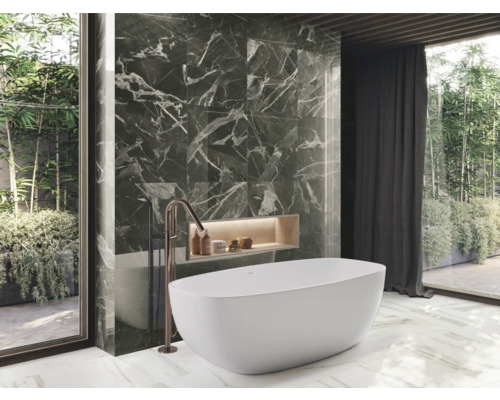 Koupelna s vanou, baterií a obkladem stěn s mramorovým vzhledem pro moderní atmosféru