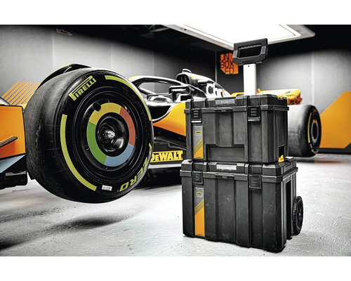 Box na nářadí se závodním vozem v pozadí