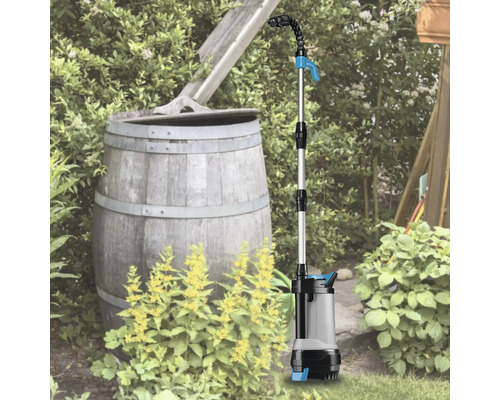 Čerpadlo do dešťové nádrže používané na zahradě vedle sudu na dešťovou vodu