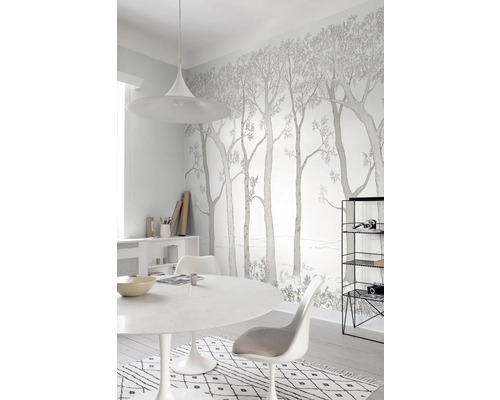 Světlá místnost s tapetou s motivem lesa, jídelním stolem a židlemi pro přátelskou atmosféru.