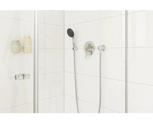 Detailní pohled na sprchu s baterií, ruční sprchou a dávkovačem mýdla na stěně sprchy