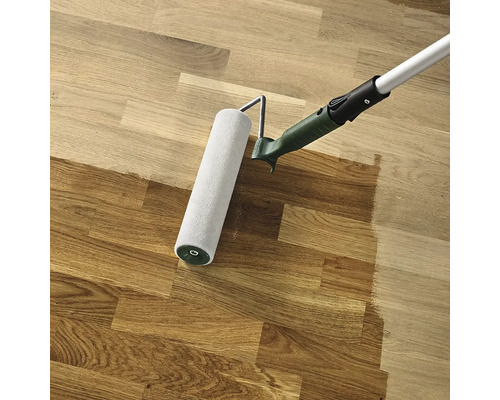 Váleček nanáší barvu na dřevěnou podlahu