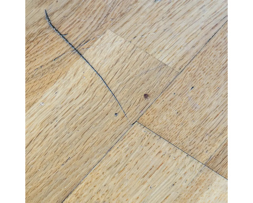 Dřevěná parketová podlaha s poškozením