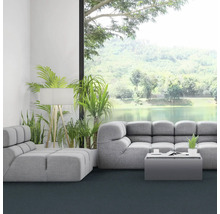 Světlý obývací pokoj se šedou pohovkou, pokojovými rostlinami a velkým oknem s výhledem na jezero