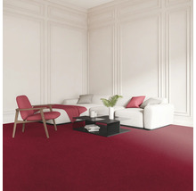 Obývací pokoj s červeným kobercem, bílou pohovkou, křeslem a černým konferenčním stolkem