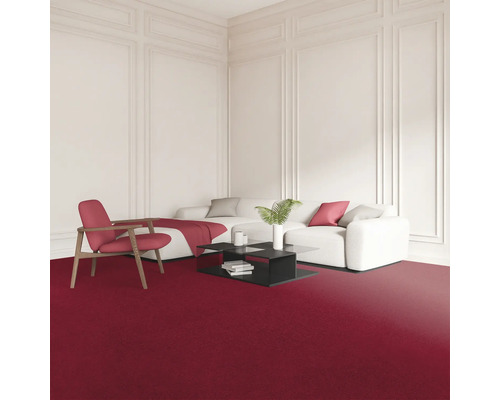 Obývací pokoj s červeným kobercem, bílou pohovkou, křeslem a černým konferenčním stolkem