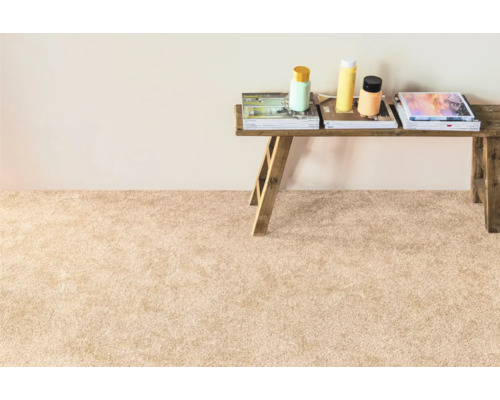 Béžový koberec s dřevěnou lavicí, knihami a lahvemi