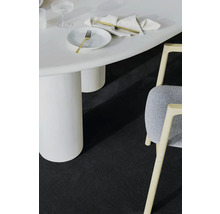 Detailní záběr místnosti s bílým stolem, židlí a tmavým kobercem