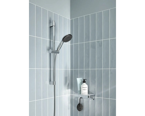 Sprchová hlavice s tyčí a poličkou s kosmetickými produkty na obložené sprchové stěně