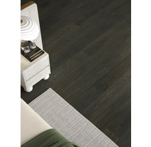 Pohled na pokoj s podlahou z tmavých dřevěných parket.