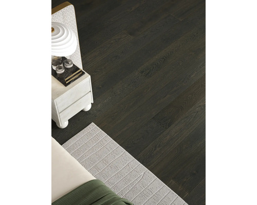 Pohled na pokoj s podlahou z tmavých dřevěných parket.