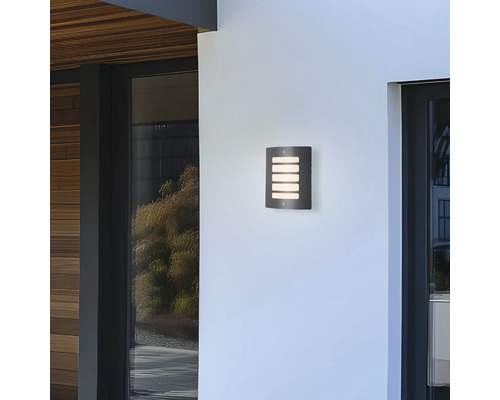 Kovové nástěnné svítidlo se čtyřmi světelnými štěrbinami na stěně domu