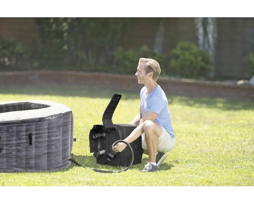 Muž připojuje nafukovací vířivou vanu k topnému zařízení