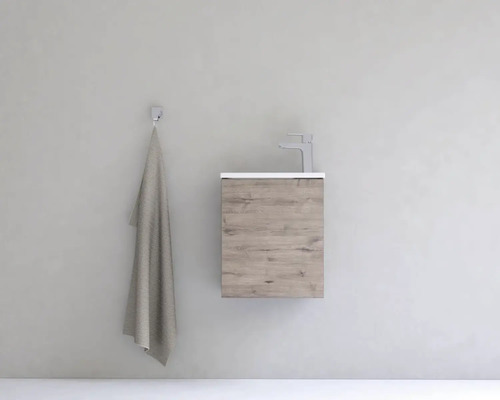 Umyvadlo s vodovodní baterií a ručníkem na zdi