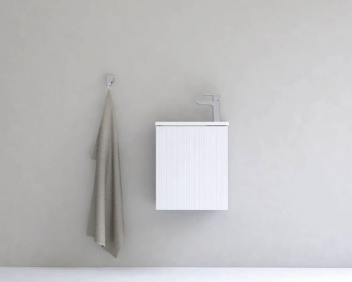 Umyvadlo s vodovodní baterií a ručníkem na zdi