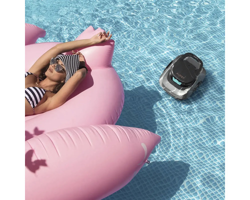 Scéna s ženou na nafukovacím plameňáku v bazénu a robotický čistič bazénu