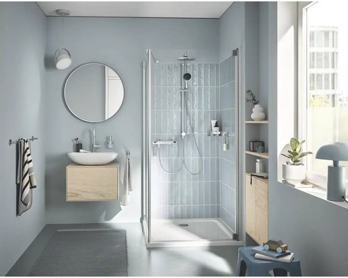 Světlá koupelna se sprchou, umyvadlem, zrcadlem a úložnými prostory pro moderní atmosféru.