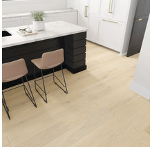 Světlá dřevěná podlaha v kuchyni s kuchyňským ostrovem a barovými stoličkami.