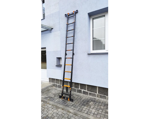 Rozložený teleskopický hliníkový žebřík opřený o stěnu domu