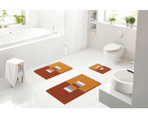 Koupelna s vanou, toaletou, umyvadlem a sadou koupelnových předložek s geometrickým vzorem