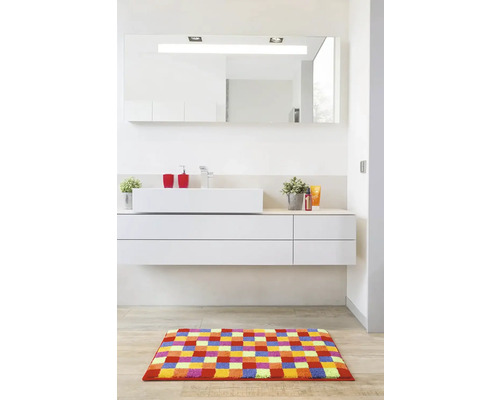 Moderní koupelna s umyvadlem, zrcadlem, koupelnovým kobercem a koupelnovým nábytkem