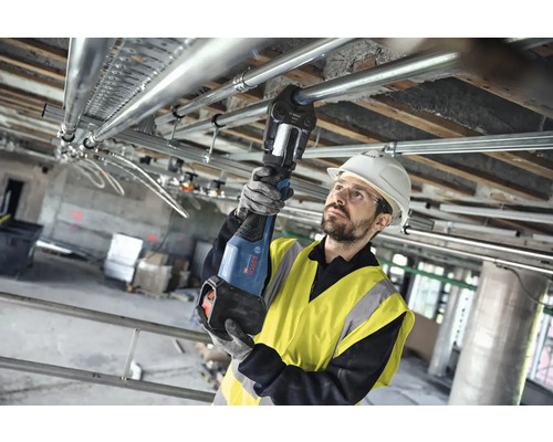 Instalatér montuje potrubí ke stropu pomocí akumulátorového lisovacího nástroje.