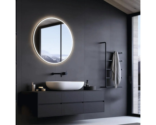 Moderní koupelna s kulatým zrcadlem, umyvadlem a držákem na ručníky