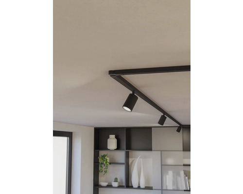 Černý kolejnicový systém s několika bodovými světly na stropě.