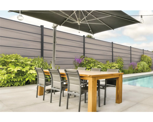 Terasa se zahradním plotem, slunečníkem, jídelním stolem a židlemi