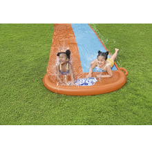 Dvě děti se baví na vodní skluzavce na zahradě.