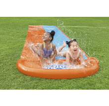 Dvě děti se baví na vodní skluzavce na zahradě.