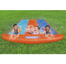 Vodní skluzavka se třemi dětmi na zahradě na trávníku