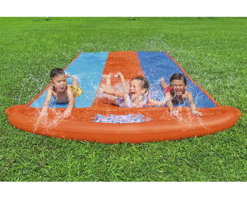 Vodní skluzavka se třemi dětmi na zahradě na trávníku