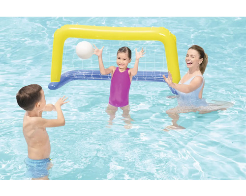 Scéna s dětmi a ženou hrající si v bazénu s nafukovací brankou na vodní pólo.
