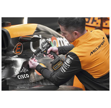 Muž pracuje s akumulátorovou vrtačkou Dewalt na závodním autě.