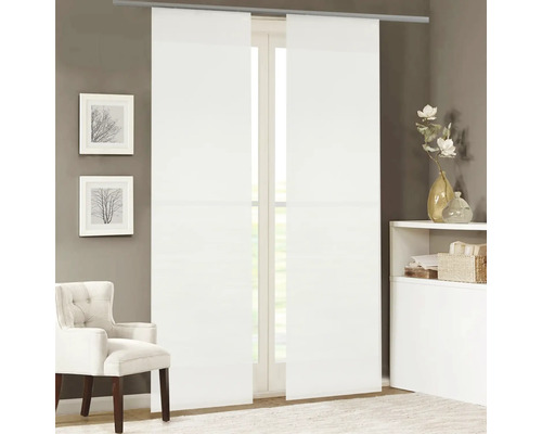 Dva bílé posuvné závěsy před oknem, doplněné křeslem a dekoračními předměty v místnosti.