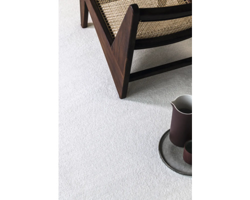 Detailní pohled na světlý koberec se židlí a dekorací