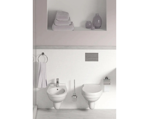 Světlá koupelna s bidetem a toaletou na stěně, držák na ručníky a police