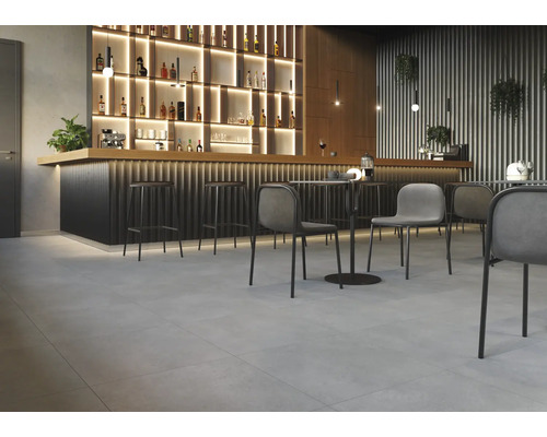 Interiér s barem, barovými stoličkami, stoly a židlemi na dlaždicové podlaze.